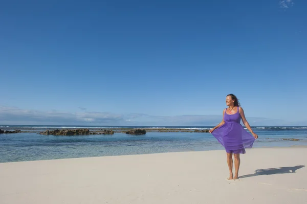 Sexy žena fialové šaty šťastný na dovolenou na pláži — Stock fotografie