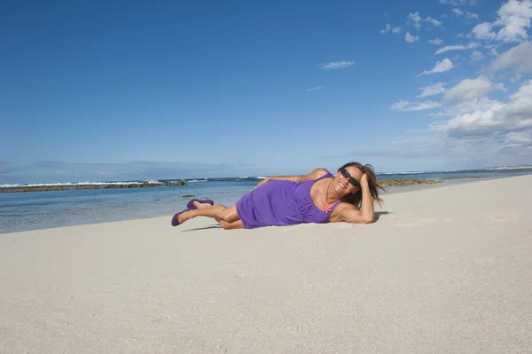 Сексуальная женщина в фиолетовом платье счастлива на пляжном отдыхе — стоковое фото