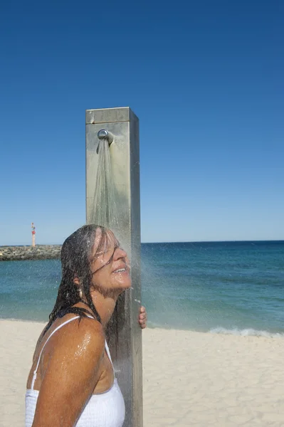 Сексуальная женщина принимает душ под открытым небом на пляже — стоковое фото