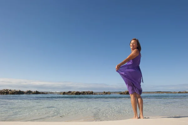 보라색 드레스를 입고 행복 한 해변에서 섹시 한 여자 — 스톡 사진