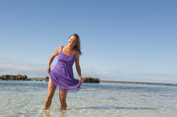 Mulher sexy em vestido roxo feliz na praia — Fotografia de Stock