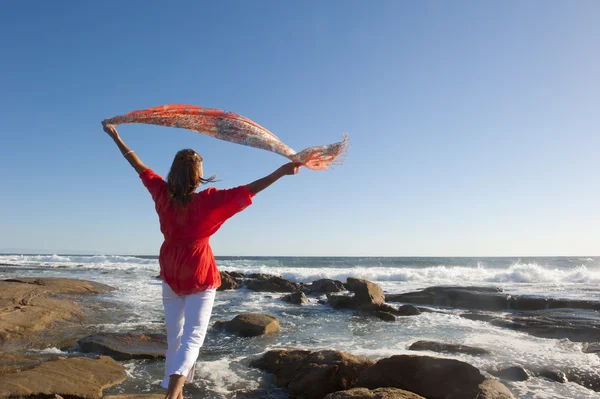 Sexy radostné žena s vlající látky v oceánu pozadí — Stock fotografie