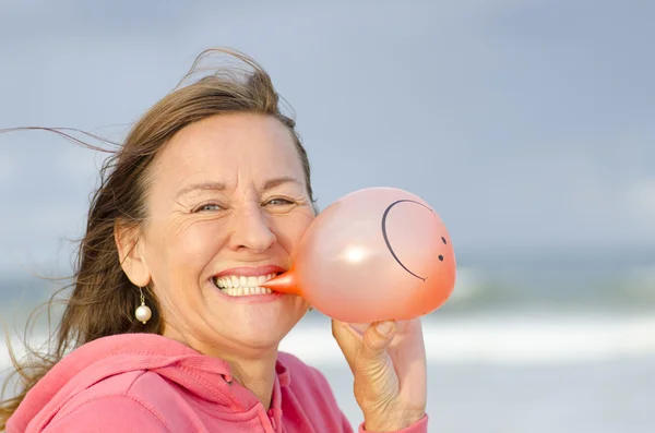 Gelukkig en blije vrouw met smiley ballon — Stockfoto