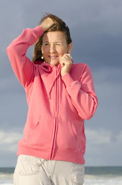 Volwassen vrouw ontspannen op winderige koude dag in ocean — Stockfoto