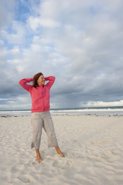 Volwassen vrouw ontspannen op winderige koude dag in ocean — Stockfoto