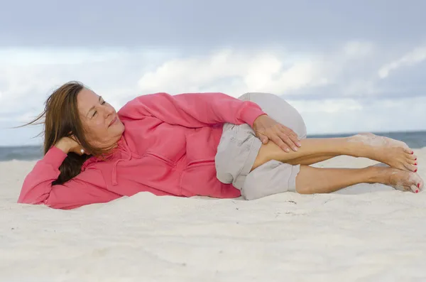 Привлекательная зрелая женщина расслабленная, счастливая на пляже — стоковое фото