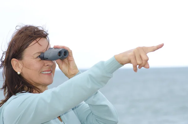 Pretty mature woman with binoculars — Stock Photo, Image
