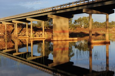 Bridge over tranquil river outback Australia clipart