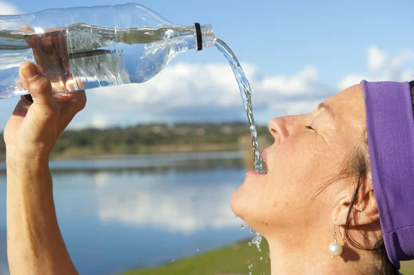 Active senior woman refreshing drink — Stock Photo, Image