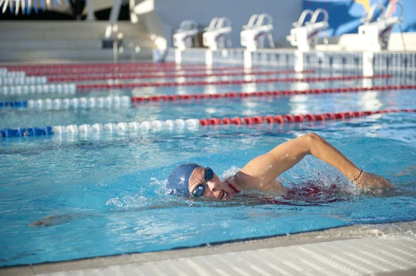 Mulher idosa ativa nadando na piscina — Fotografia de Stock