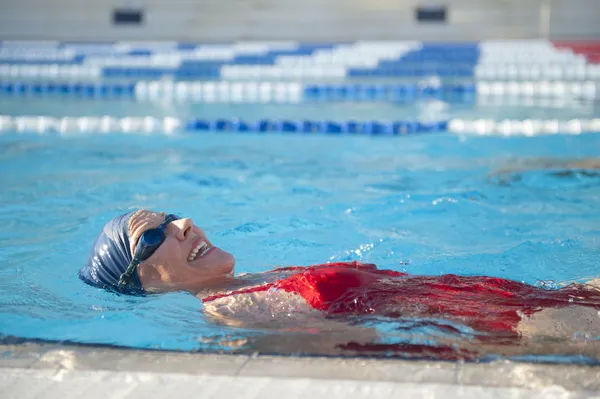Активная старшая женщина плавает в бассейне Стоковая Картинка