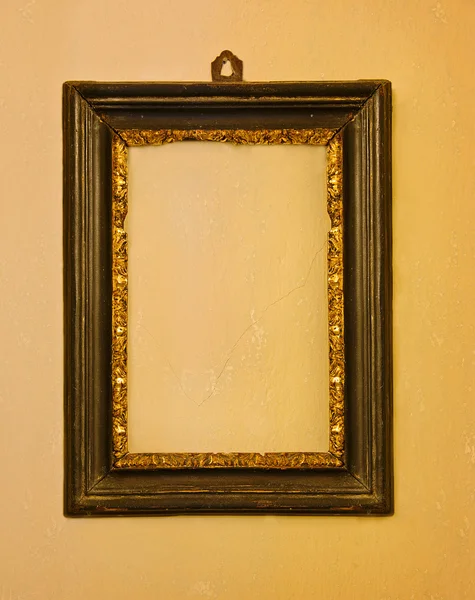 Old wooden frame on a yellow wall — Stock Photo, Image
