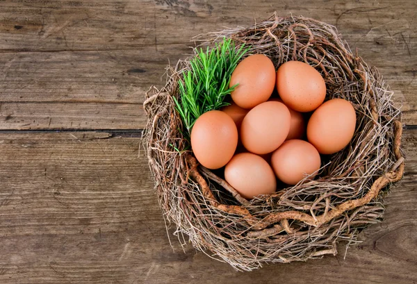 Eieren in een mand op een houten ondergrond — Stockfoto