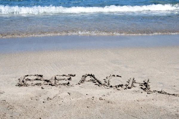 Stranden skriven på en sandstrand — Stockfoto