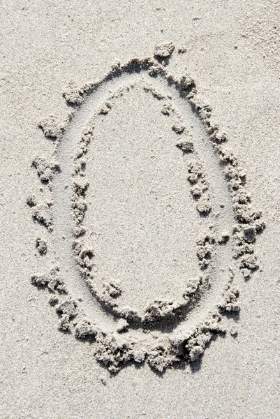 Алфавит песчаного пляжа: буква O — стоковое фото