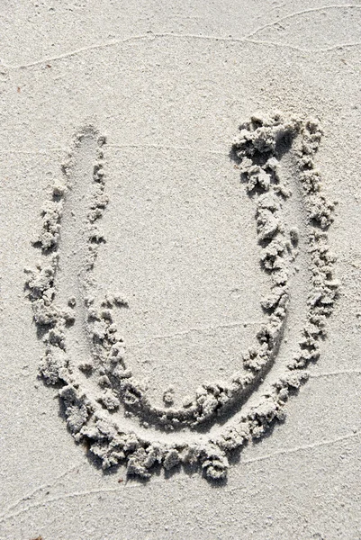 Алфавит песчаного пляжа: буква U — стоковое фото