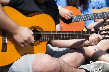 Young playing guitar together clipart