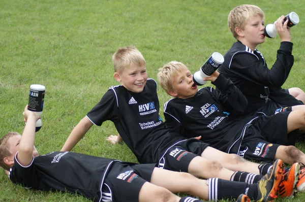 Děti pít poté, co fotbalové utkání na hřišti — Stock fotografie