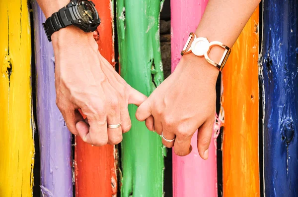 Hand in hand with colorful bamboo background — Stock Photo, Image