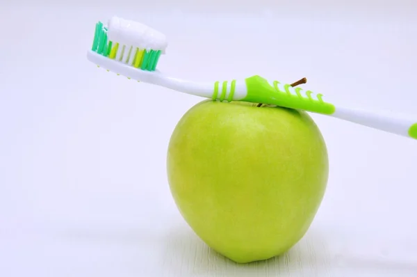 Grüner Apfel und Zahnbürste Stockbild
