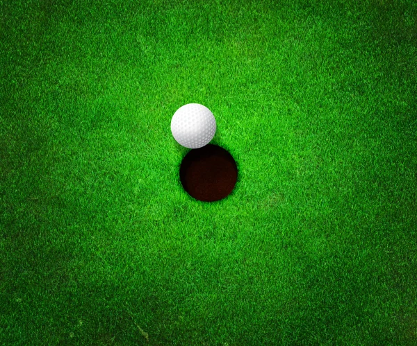 Мяч рядом с отверстием для гольфа — стоковое фото