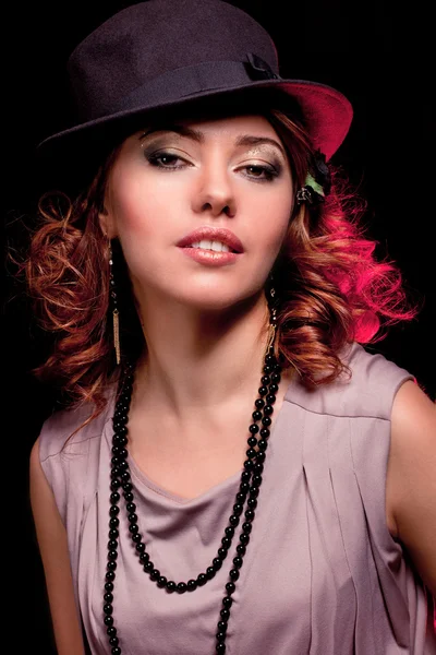 La bella donna in elegante a un cappello su sfondo nero cl — Foto Stock