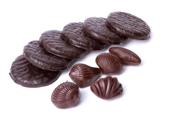 Six biscuits et cinq chocolats sur le fond blanc — Photo