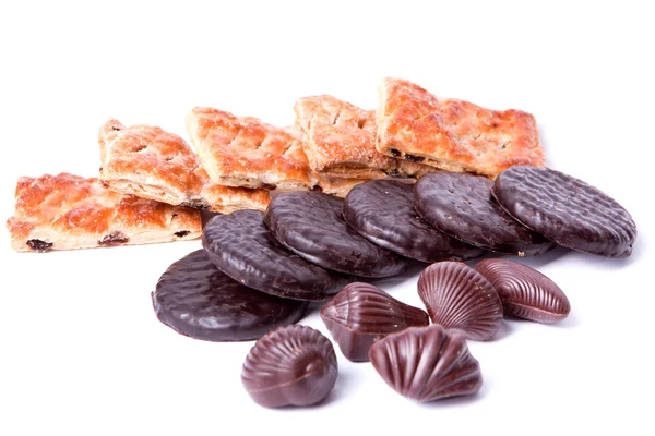 Chocolats, biscuits au chocolat et pain de fantaisie crépitant sur un whi — Photo
