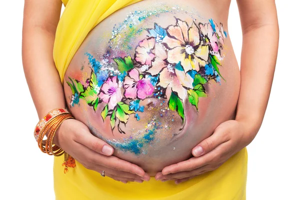 Gravid tjej med den ritade bilden på en mage på en vit bac — Stockfoto