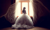 A gyönyörű menyasszony ellen egy ablak bent