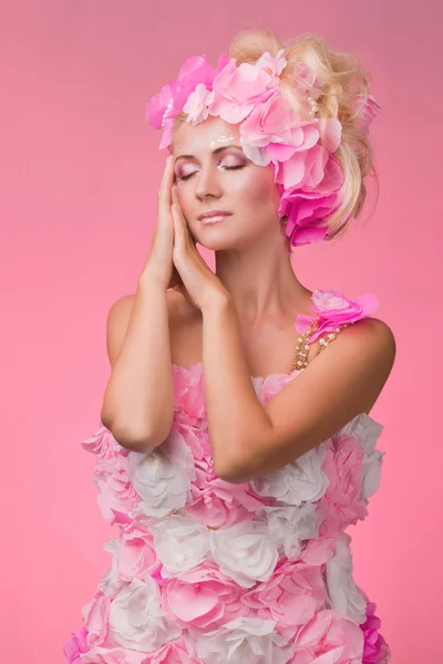 La bella ragazza in un'immagine di primavera in un vestito fiorente su un — Foto Stock