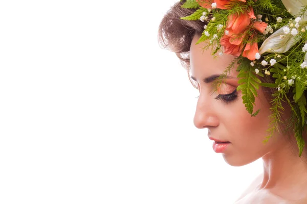 Uma menina bonita com flores na cabeça em um fundo branco — Fotografia de Stock