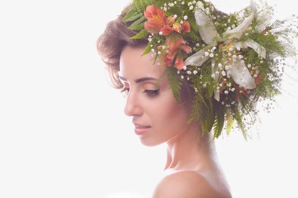 Ein schönes Mädchen mit Blumen auf dem Kopf auf weißem Hintergrund — Stockfoto