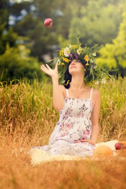 Pregnant woman in the dry grass tosses an apple clipart