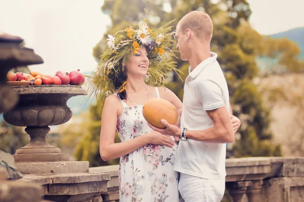 Una pareja enamorada durante el embarazo en el parque con frutas —  Fotos de Stock