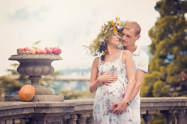 Пара влюбленных во время беременности в парке с фруктами и мелами — стоковое фото