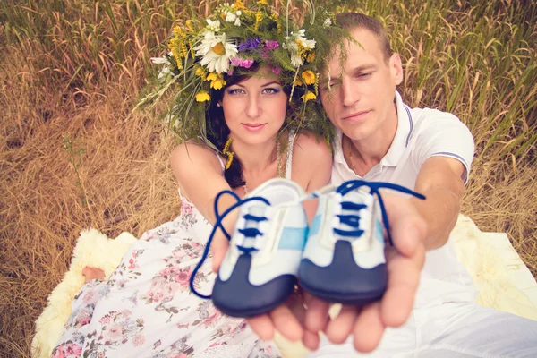Пара влюблённых во время беременности в парке с молодым Сникером — стоковое фото