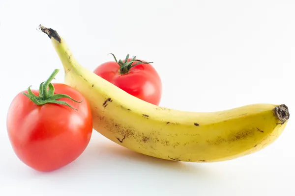 Plátano y tomates que representan los genitales masculinos — Foto de Stock
