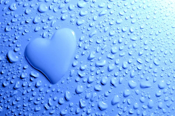 Water druppels en hart vorm op blauwe achtergrond — Stockfoto