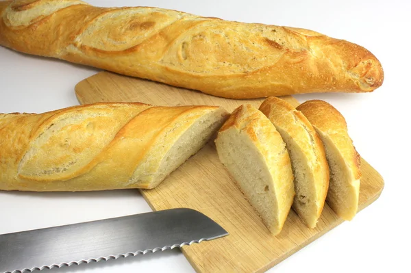 Sliced fresh baguette and bread knife — Stock Photo, Image