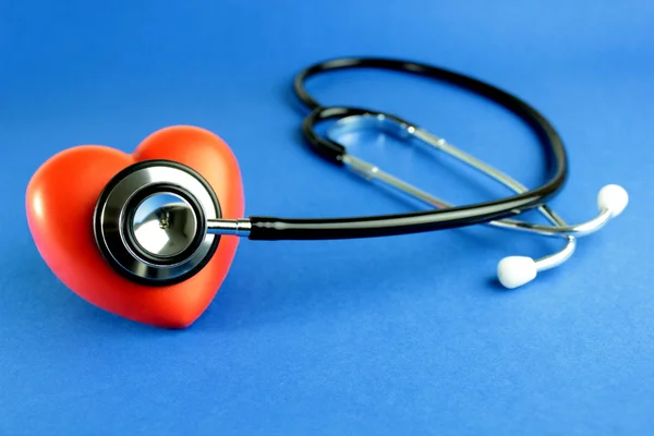 Stetoskop och rött hjärta på blå bakgrund — Stockfoto