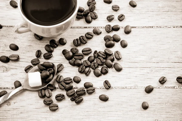 Šálek kávy a fazole, cukru, lžíce. — Stock fotografie