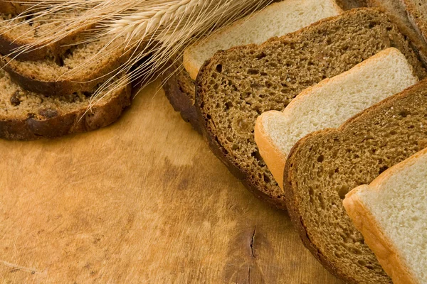 Leckere Semmeln und Brot auf Holz — Stockfoto