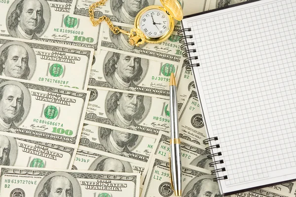 Σημειωματάριο, στυλό και το ρολόι σε δολάρια — Φωτογραφία Αρχείου