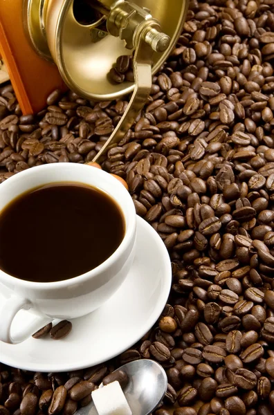 Grãos de café, xícara e moedor — Fotografia de Stock