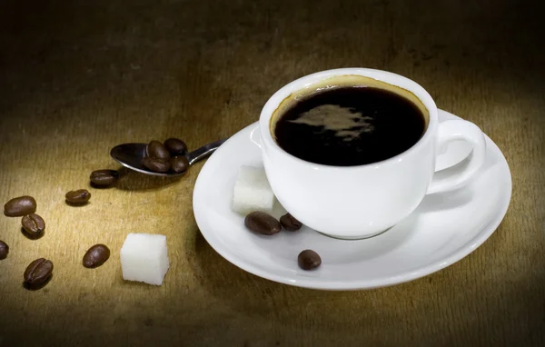 Tasse Kaffee und Bohnen auf Holz — Stockfoto