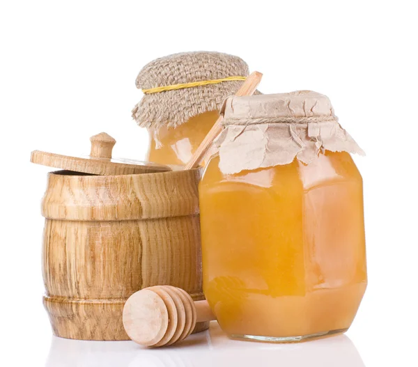 Jars and pot full of honey isolated on white — Stock Photo, Image
