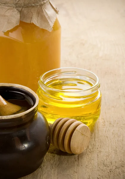 Honey in jars and pot on wood — Stock Photo, Image