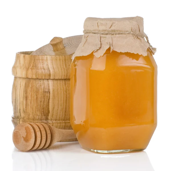 Pots en verre et en bois remplis de miel isolé sur blanc — Photo