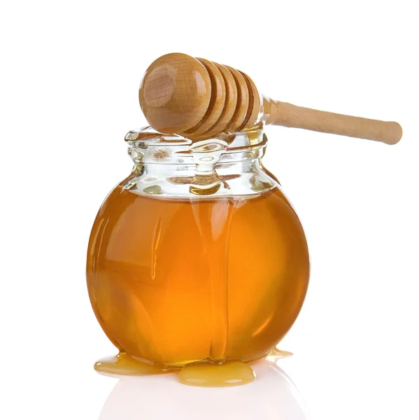 Glass jar of honey and stick isolated on white — Stock Photo, Image